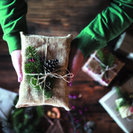 Foto von H&auml;nden, die ein in Jute eingepacktes Weihnachtsgeschenk halten