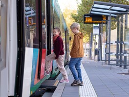 Zwei Kinder steigen in einen Bus ein